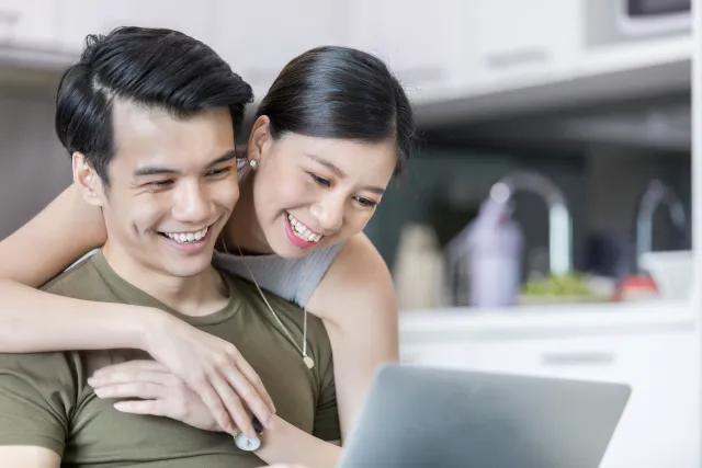 Couple Smiling While using laptop