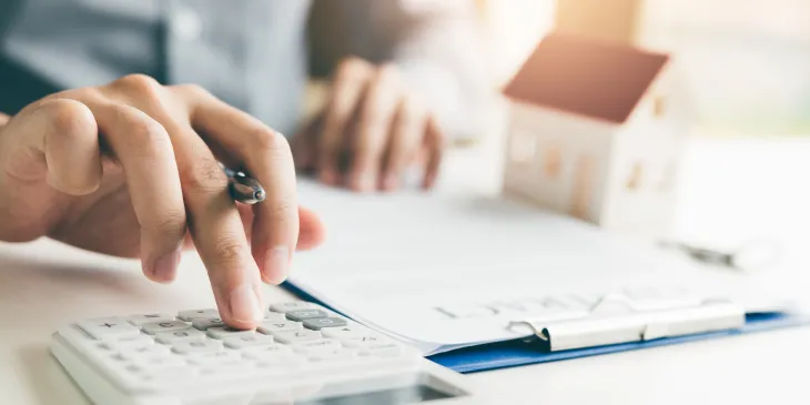 Man using calculator and looking over paperwork