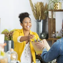 Salesperson in yellow jacket handing over purchase